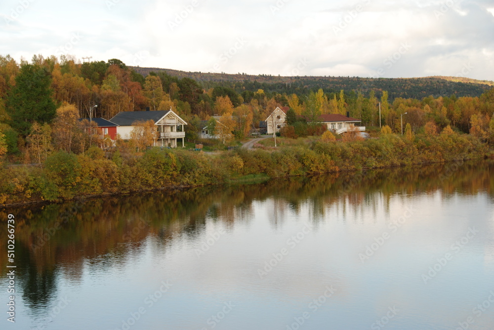 Karasjok village in autumn colors reflected in Karasjohka River, Finnmark, Norway Karasjok village in autumn colors reflected in Karasjohka River, Finnmark, Norway