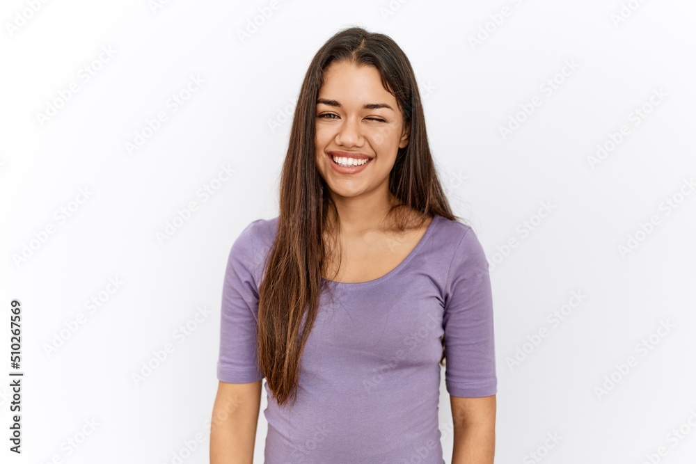 Young brunette woman standing by isolated background winking looking at the camera with sexy expression, cheerful and happy face. Young brunette woman standing by isolated background winking looking at the camera with sexy expression, cheerful and happy face.