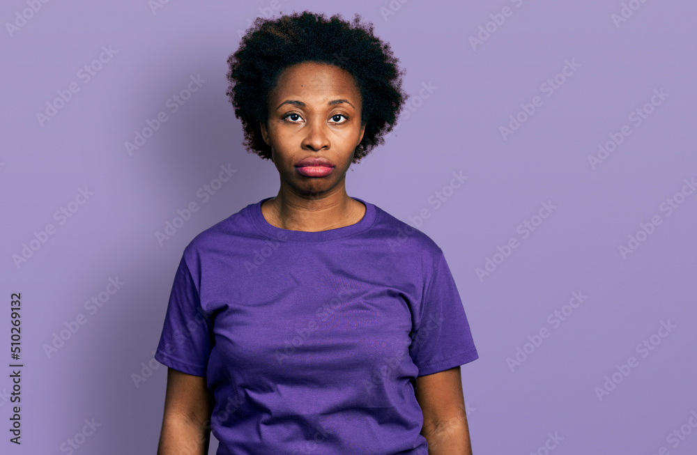 African american woman with afro hair wearing casual purple t shirt looking sleepy and tired, exhausted for fatigue and hangover, lazy eyes in the morning. African american woman with afro hair wearing casual purple t shirt looking sleepy and tired, exhausted for fatigue and hangover, lazy eyes in the morning.