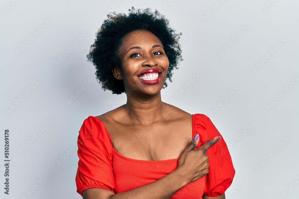 Young african american woman wearing casual clothes cheerful with a smile of face pointing with hand and finger up to the side with happy and natural expression on face Young african american woman wearing casual clothes cheerful with a smile of face pointing with hand and finger up to the side with happy and natural expression on face