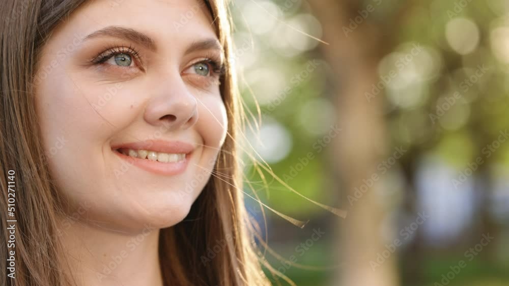 Face attractive brunette woman at sunset smiling beautiful around blue eyes. Stand outdoor relax. Happy relax. Close up. Slow motion. Face attractive brunette woman at sunset smiling beautiful around blue eyes. Stand outdoor relax. Happy relax. Close up. Slow motion.