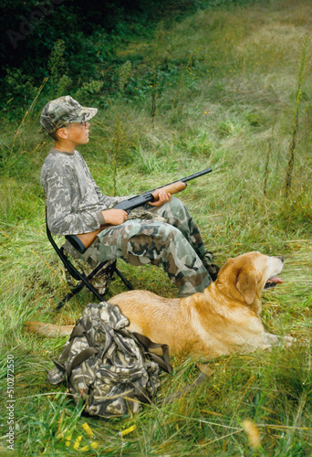 A young hunter and his Lab wait for doves