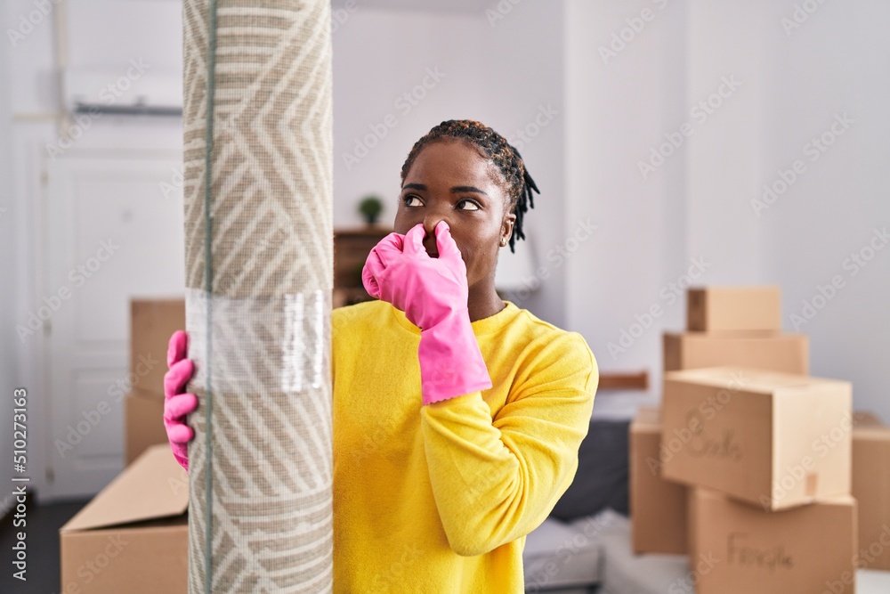 African american woman holding dirty capert at new home African american woman holding dirty capert at new home