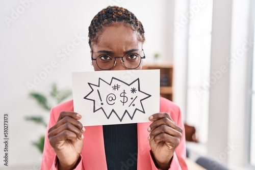 African american woman business worker holding insult banner at office photo