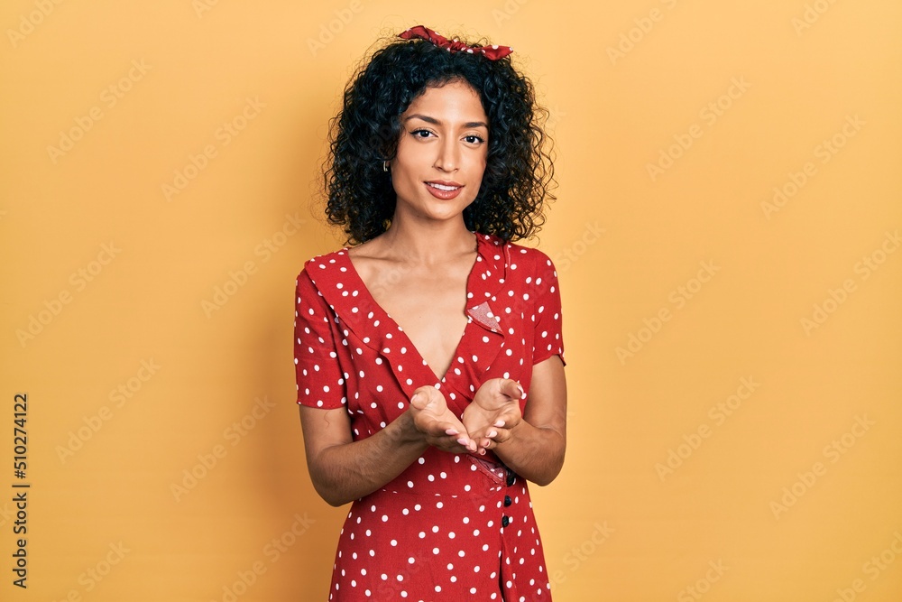 Young latin girl wearing summer dress smiling with hands palms together receiving or giving gesture. hold and protection Young latin girl wearing summer dress smiling with hands palms together receiving or giving gesture. hold and protection