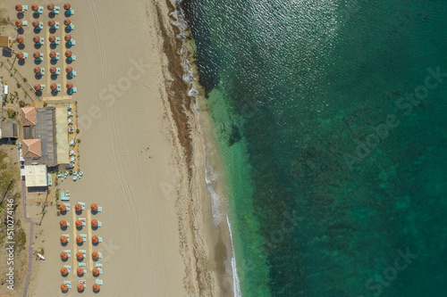 Vista aerea de playa paradisiaca con sombrillas y tumbonadas para tomar el sol photo