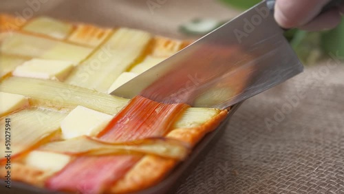 The chef cuts a freshly baked rhubarb pie with a knife, the idea of making traditional Siberian pies from seasonal products, live footage, 4k video.