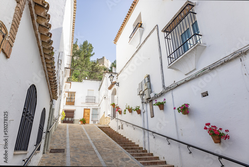 Typical narrow street in Zahara de la Sierra, in Sierra de Grazalema, Cadiz, Andalusia, Spain photo