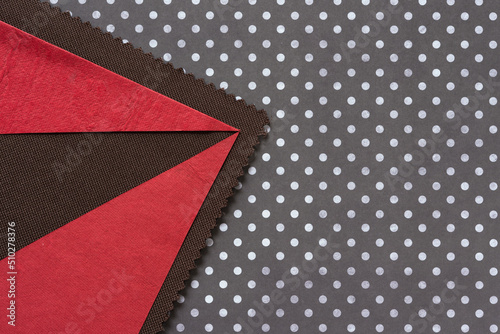 red paper shapes on brown fabric and paper with dots