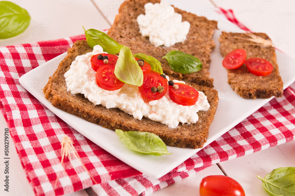 Rye bread with cottage cheese, basil and tomato.