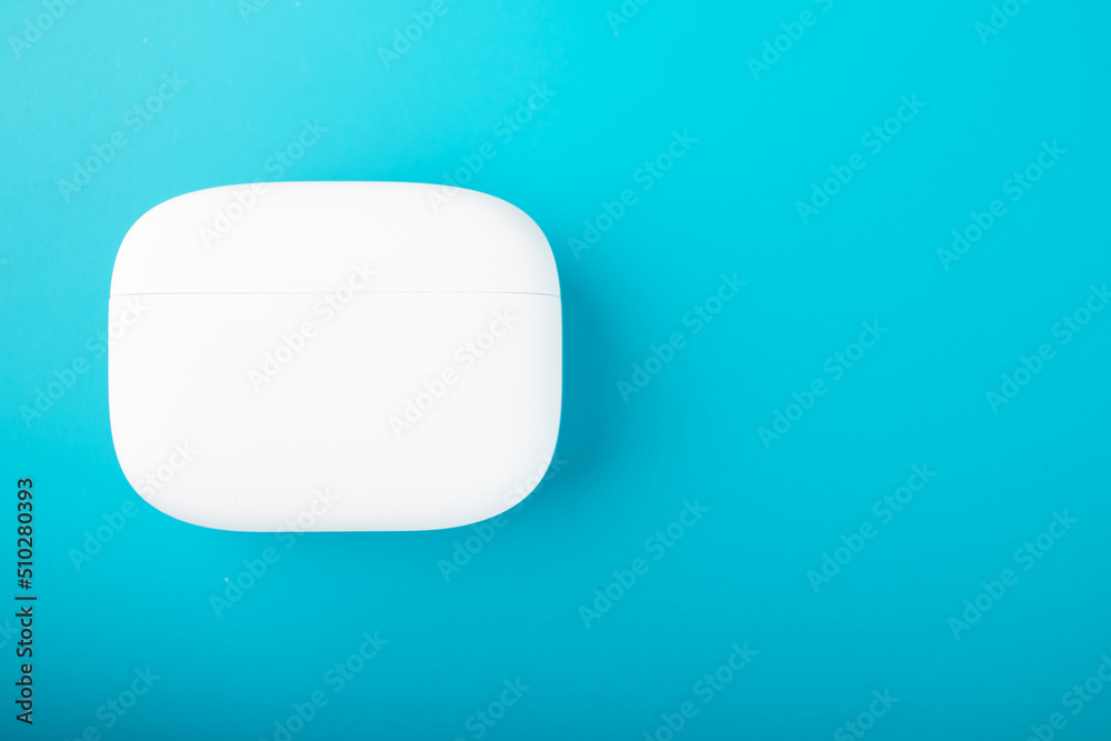 charging case for wireless headphones on a blue background with copy space charging case for wireless headphones on a blue background with copy space
