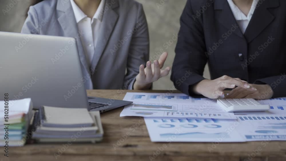 Investment advisor 2 business people analyze company financial statements working with document graphs for stock market, office, tax and project team of data analysts working with tablet computers.