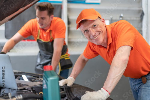 Portrait of senior mechanics man with team checking and repairing car in auto service garage.Technician maintenance car engine