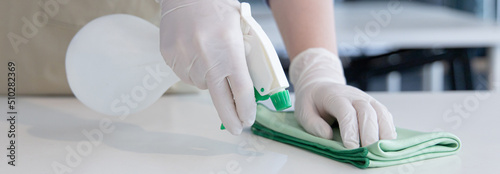 Close up Staff hand Restaurant workers are cleaning table and spraying disinfectants during the virus outbreak, Using cleaning solutions or using alcohol to kill germs in the restaurant.