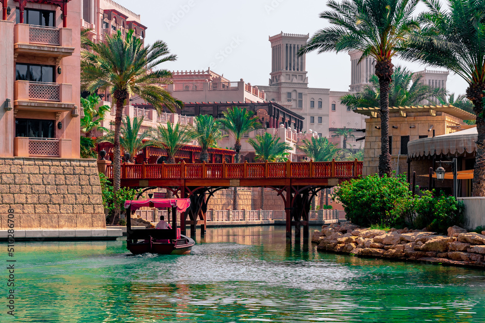 5 June 2022 - Dubai, UAE: Red abra in Souk Madinat Jumeriah waterway and resorts