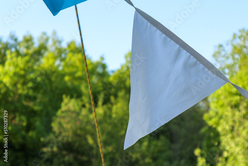 triangular white flag on the stretch close-up. garden party