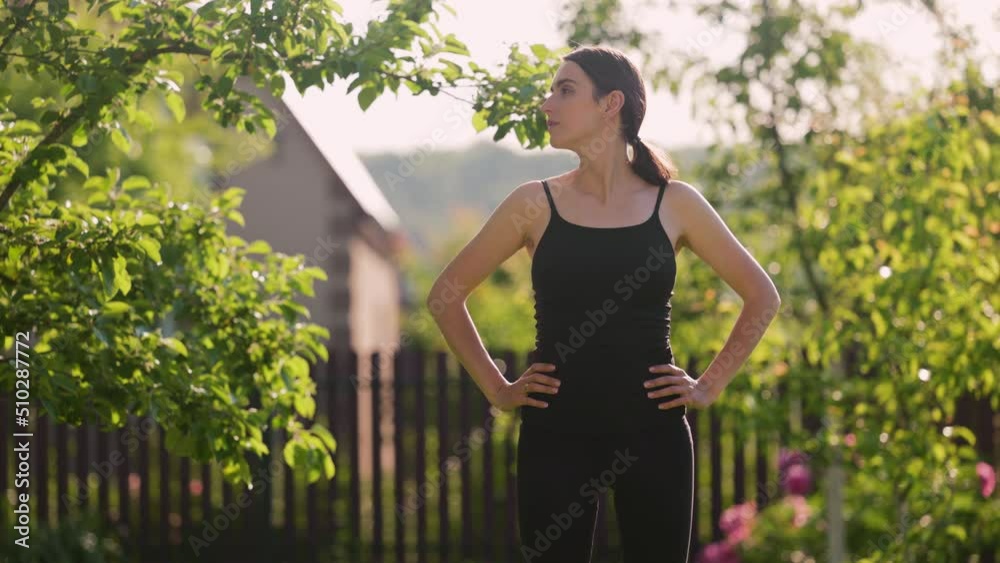 Woman in sportswear doing workout burning fat calories training strength practicing effort domestic fitness females aerobics sport fit in backyard. Kneads his neck, shakes his head. Woman in sportswear doing workout burning fat calories training strength practicing effort domestic fitness females aerobics sport fit in backyard. Kneads his neck, shakes his head.