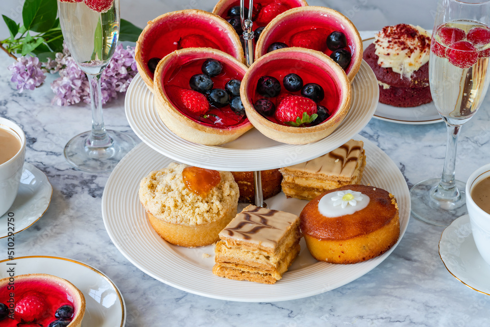 Selection of gourmet cakes with coffee and sparkling wine on a table Selection of gourmet cakes with coffee and sparkling wine on a table