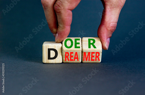 Doer or dreamer symbol. Concept words Doer or dreamer on wooden cubes. Businessman hand. Beautiful grey table grey background. Business and doer or dreamer concept. Copy space.