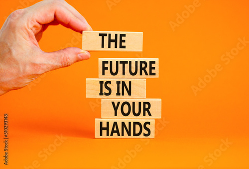 The future is in your hands symbol. Concept words The future is in your hands on wooden blocks on a beautiful orange table orange background. Businessman hand. Business future in your hands concept.