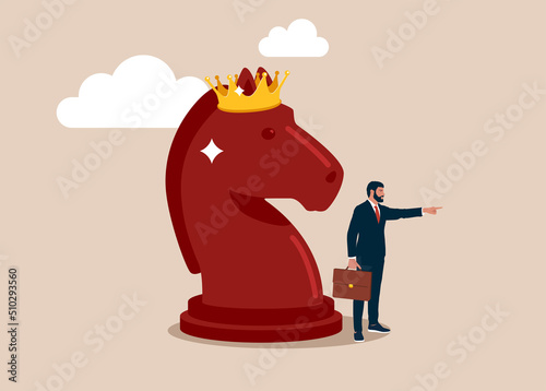 Entrepreneur pointing finger to direct chess knight with king crown. Strategy to win business competition, leadership to make decision, business challenge or tactic to overcome obstacle concept.