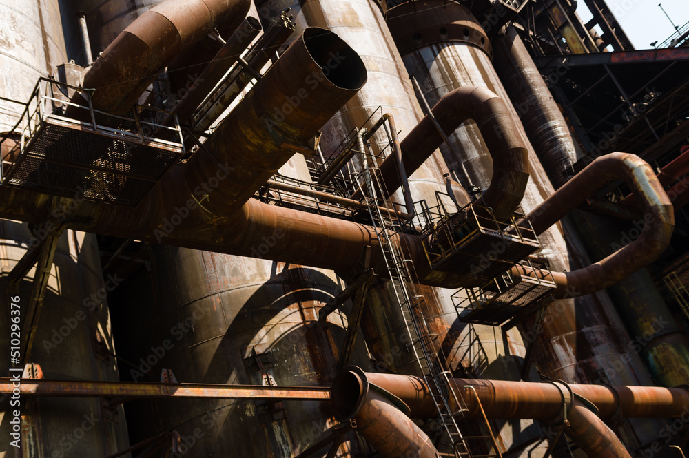 Massive rusty system of tubes and pipes in adandoned industrial area