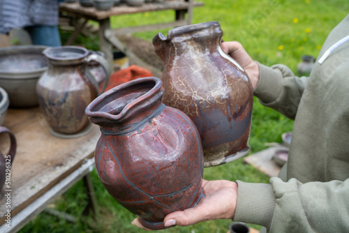fired earthenware removed from the kiln. The woman looks at the outcome. Mugs, pots, plates and everything else beautiful and useful. Latvian national cultural heritage