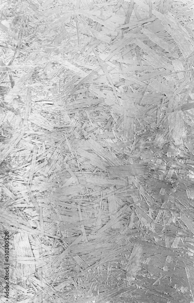 Silver chipboard. The background image of the chipboard. Just a texture. Top view of OSB veneer, dense, seamless surfaces. Silver chipboard. The background image of the chipboard. Just a texture. Top view of OSB veneer, dense, seamless surfaces.