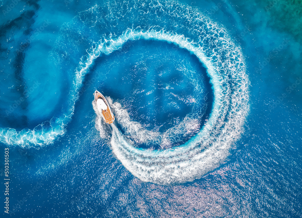 Aerial view of the speed boat in clear blue water at sunset in summer ...