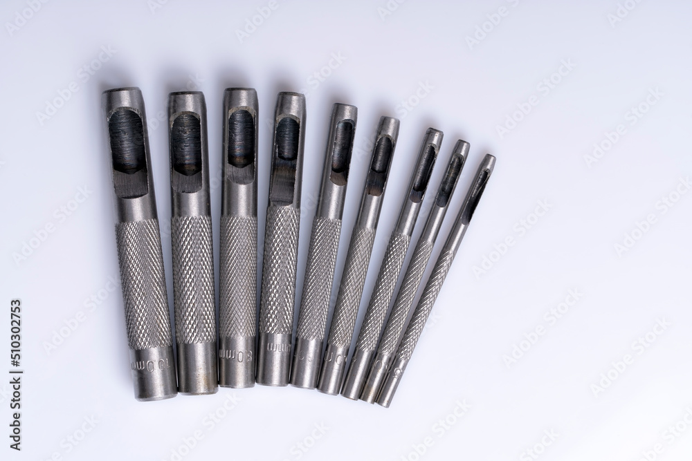 Macro detail of a set of steel punches isolated on white