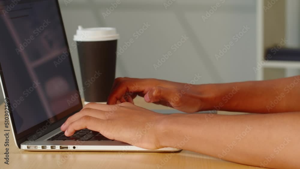 African American man typing on laptop keyboard close-up. Young guy working in office. Businessman texting on computer, copywriter.
