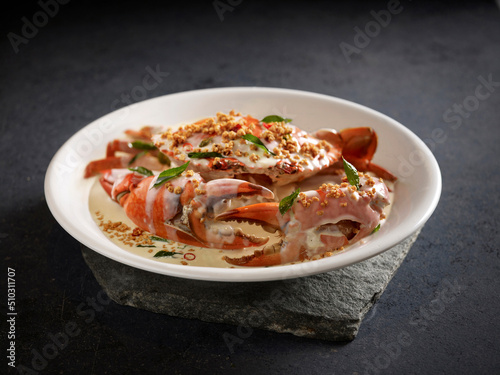 Signature Creamy Butter Sri Lankan Crab topped with Coconut Crumbs served in a dish side view on dark background