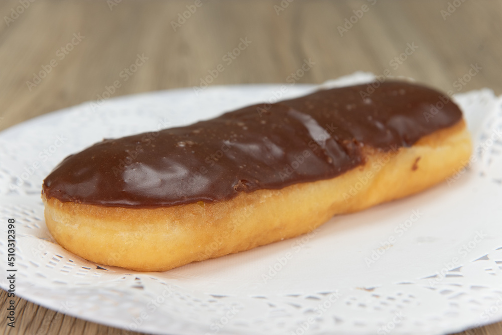 Tempting fresh from the oven chocolate bar donut from the bakery served on a plate Tempting fresh from the oven chocolate bar donut from the bakery served on a plate