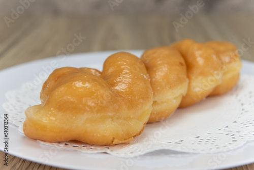Tempting fresh from the oven glazed twist donut from the bakery served on a plate