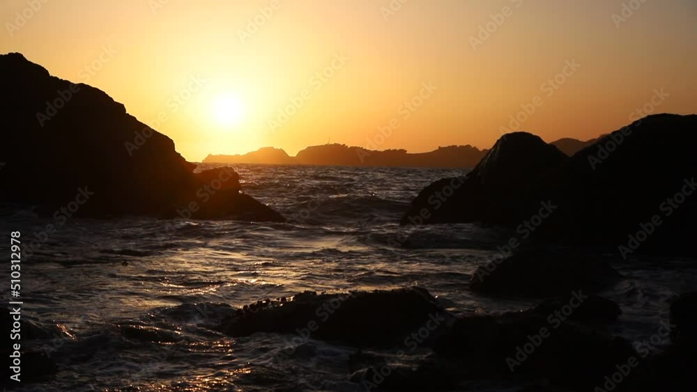 Ocean waves crashing over rocks on west coast at sunset Ocean waves crashing over rocks on west coast at sunset