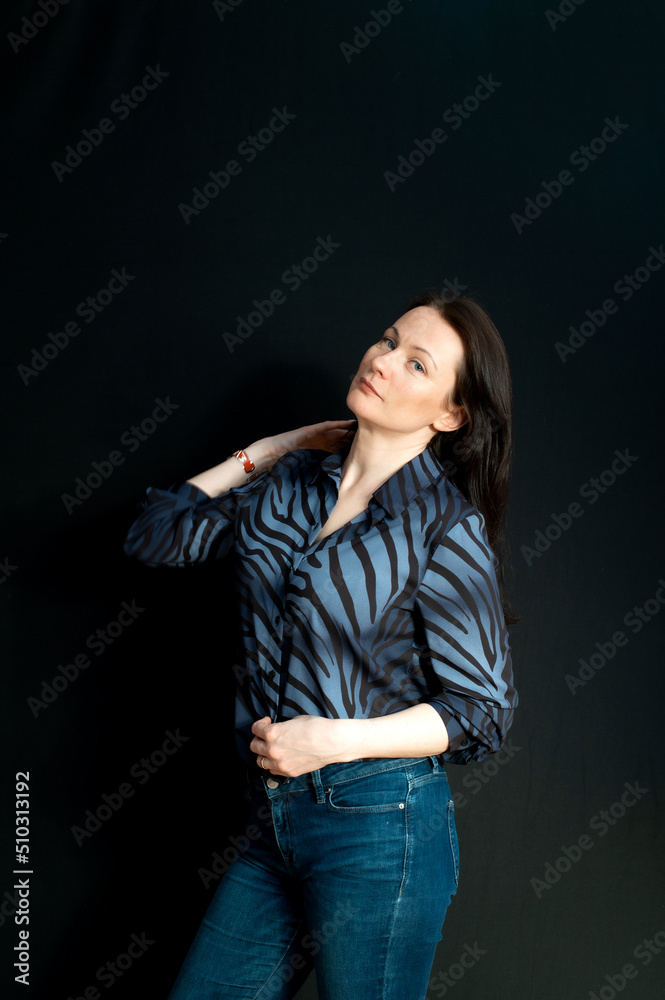 portrait of a young serious brunette on a dark studio background portrait of a young serious brunette on a dark studio background