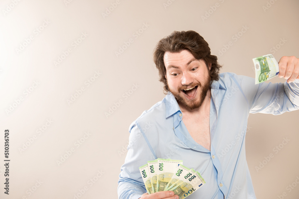 Portrait of happy caucasian man holding in hands 100 euro banknotes isolated over gray background Portrait of happy caucasian man holding in hands 100 euro banknotes isolated over gray background