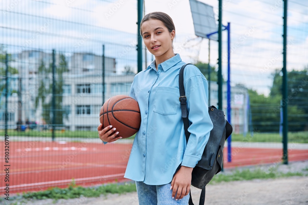 Portrait of teenage student girl with backpack and basketball ball