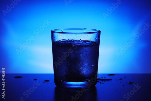 A glass with water at blue background