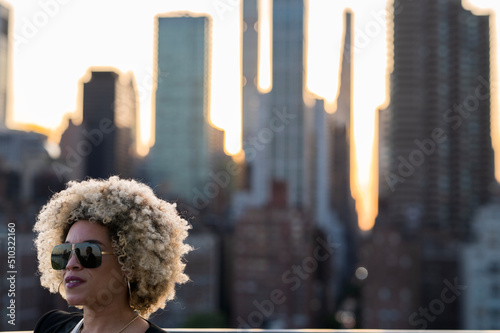 African American Woman with Blonde Afro Standing In Front of the New York Skyline