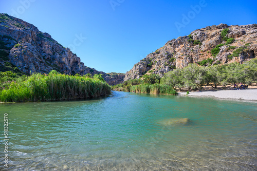 Preveli Beach - famous for the beautiful river with azure clear water and tropical palm forest behind the beach - in southern Crete island, Greece, Europe.
