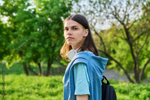 Outdoor portrait of handsome student guy with backpack looking at camera, copy space