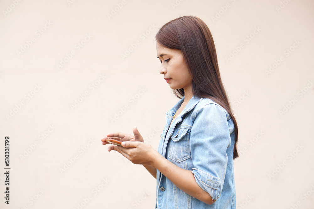 Asian women happily use their phones. because the operating results are more profitable Asian women happily use their phones. because the operating results are more profitable