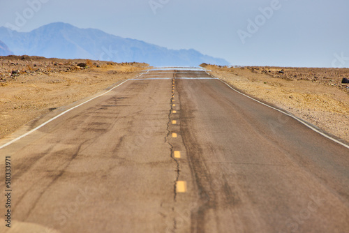 Konstfotografi Mirage captured on road in desert landscape with mountains