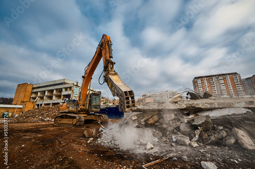 Excavator with hydraulic press breaks concrete leftovers