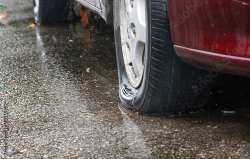 Flat tire car in rainy day on street.
