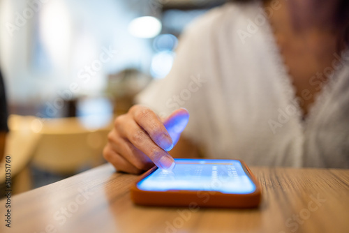 Woman use of mobile phone on the table