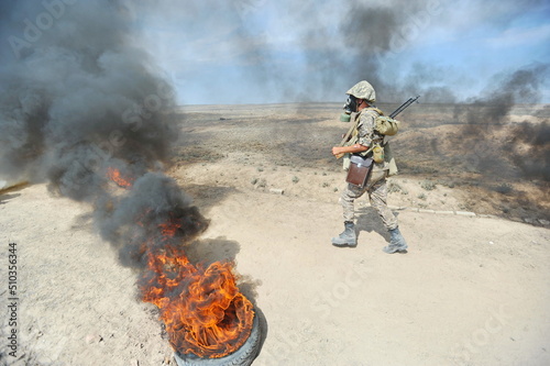 Almaty, Kazakhstan - 08.22.2012 : Soldiers pass a burning obstacle course in gas masks.