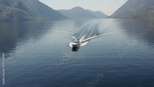 A pleasure boat goes along a picturesque lake on a sunny summer day
