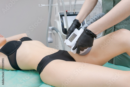Vacuum massage apparatus. Anti-cellulite body shaping procedure. Apparatus for weight loss. Woman and doctor in medicine salon. Hardware massage in a beauty salon photo
